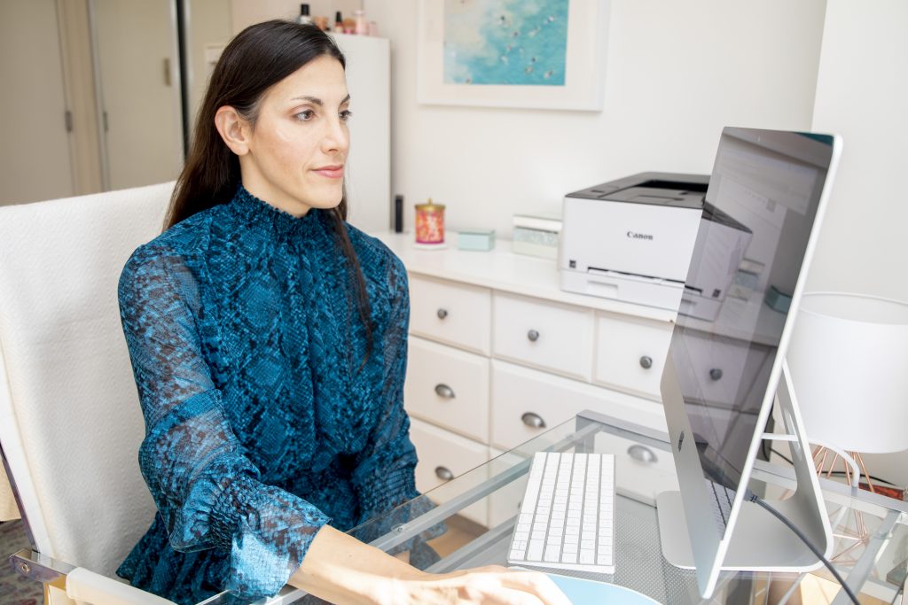 woman in blue dress at computer beauty pr agencies