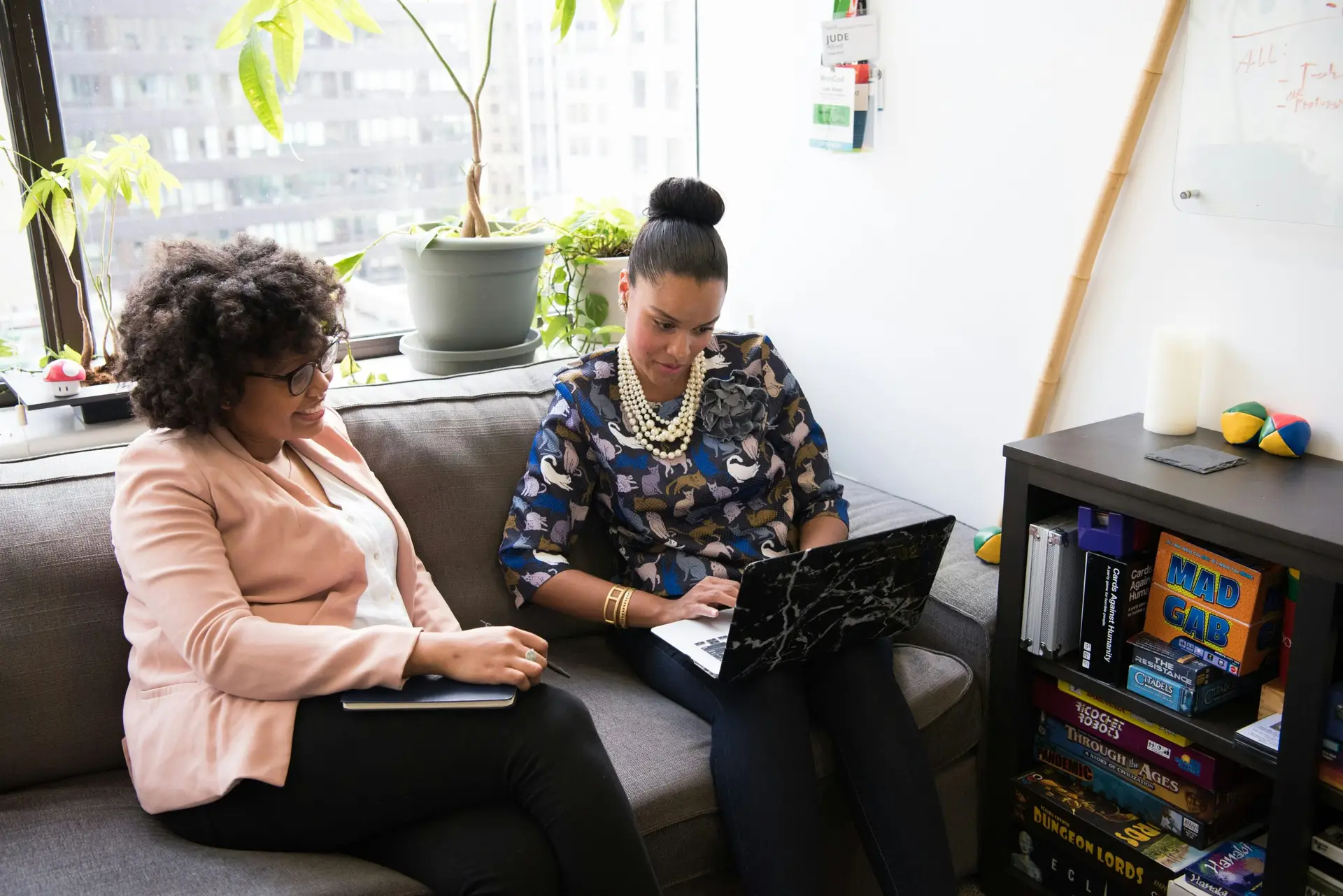 two women collaborating on couch with a laptop. beauty brand pr agency