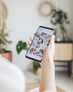 person holding white android smartphone open to instagram followers beauty fashion brands